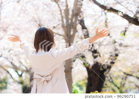 春天，櫻花盛開，微笑的女人將雙手伸向天空 96290751