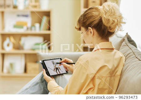 Rear view of young blond woman drawing graphic picture Rear view of young blond woman drawing graphic picture 96293473