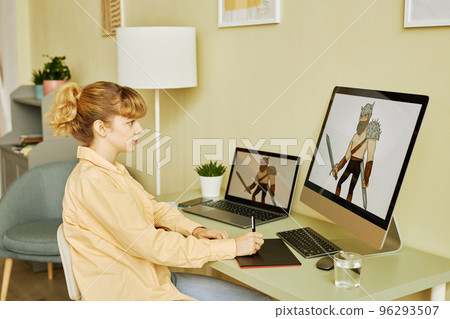 Side view of young blond female designer creating new digital pictures 96293507