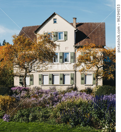 House with nice garden in fall. Flowers in the City Park of Bietigheim-Bissingen, Baden-Wuerttemberg, Germany, Europe. Autumn Park and house, nobody, bush and grenery House with nice garden in fall. Flowers in the City Park of Bietigheim-Bissingen, Baden-Wuerttemberg, Germany, Europe. Autumn Park and house, nobody, bush and grenery 96294053