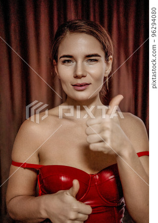 Party girl portrait. Young woman in red corset and black leather pants with photo camera. Sexy seductive brunette in red and black costume. Role play. Celebration and party. Having fun. Party girl portrait. Young woman in red corset and black leather pants with photo camera. Sexy seductive brunette in red and black costume. Role play. Celebration and party. Having fun. 96294080