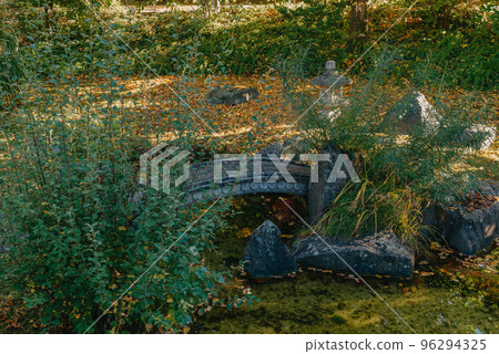 Beautiful Japanese Garden and red trees at autumn seson. A burst of fall color with pond reflections. 96294325