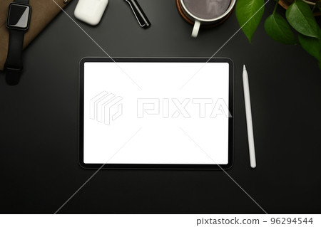 Digital tablet with white empty display, stylus pen, coffee cup and notepad on black wooden table 96294544