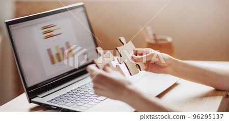 Woman holding pieces of puzzle in the office Woman holding pieces of puzzle in the office 96295137