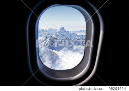 Mountains view through a jet plane window high on the blue sky 96295634