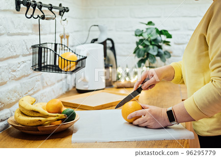How to Dry Orange Slices for Holiday Decor. Process of Drying Orange Slices in the Oven. Woman cutting slices of orange and citrus fruits for drying in oven in home kitchen How to Dry Orange Slices for Holiday Decor. Process of Drying Orange Slices in the Oven. Woman cutting slices of orange and citrus fruits for drying in oven in home kitchen 96295779