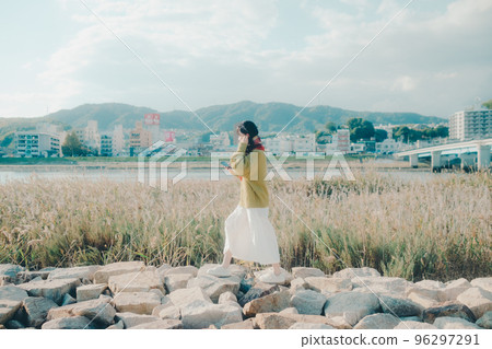 Photo of a young woman standing by a riverbed 96297291