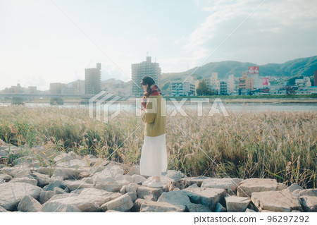 Photo of a young woman standing by a riverbed Photo of a young woman standing by a riverbed 96297292