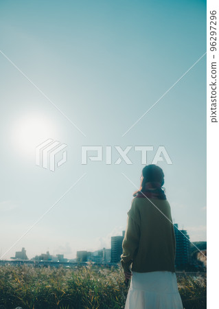 Photo of a young woman standing by a riverbed Photo of a young woman standing by a riverbed 96297296