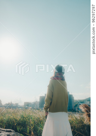Photo of a young woman standing by a riverbed Photo of a young woman standing by a riverbed 96297297