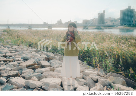 Photo of a young woman standing by a riverbed Photo of a young woman standing by a riverbed 96297298