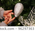Children's hands playing with the Christmas tree 96297363