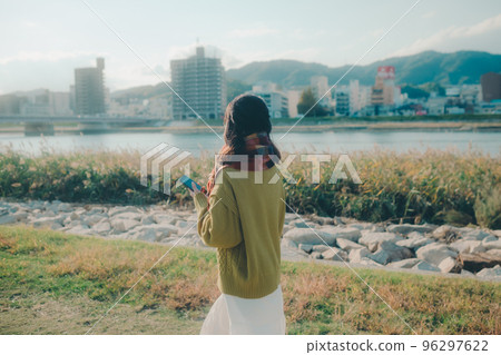 一位年輕女子在河床上邊聽音樂邊散步的照片 一位年輕女子在河床上邊聽音樂邊散步的照片 96297622