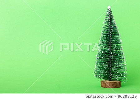 One small Christmas tree on colored background. new year decoration with copy space One small Christmas tree on colored background. new year decoration with copy space 96298129