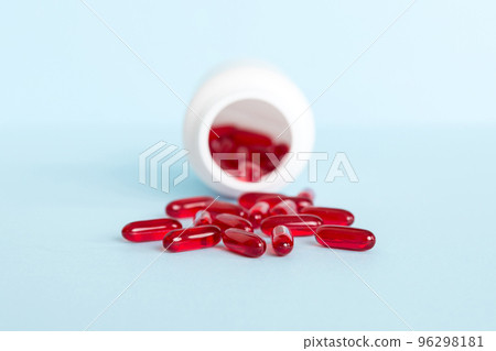 Red pills spilled around a pill bottle. Medicines and prescription pills flat lay background. Red medical capsules 96298181