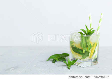 Mojito summer refreshing cocktail with ice and mint. mojito cocktail with lime, lemon and mint in a tall glass with a stick Mojito summer refreshing cocktail with ice and mint. mojito cocktail with lime, lemon and mint in a tall glass with a stick 96298196