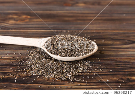 Wooden spoon and chia seeds on colored background, top view. Healthy Salvia hispanica Healthy superfood 96298217