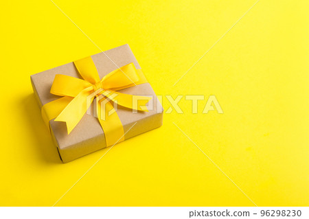Wrapped christmas or other holiday handmade present in craft paper with colored ribbon. Present box, decoration of gift on table, top view with copy space 96298230