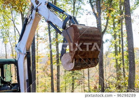 In conducts work on tractor manipulator lifts logs of process to prepare land for construction In conducts work on tractor manipulator lifts logs of process to prepare land for construction 96298289