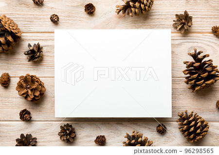Creative frame made of Christmas pine cones with square Paper blank. Xmas and New Year theme. Flat lay, top view copy space Creative frame made of Christmas pine cones with square Paper blank. Xmas and New Year theme. Flat lay, top view copy space 96298565
