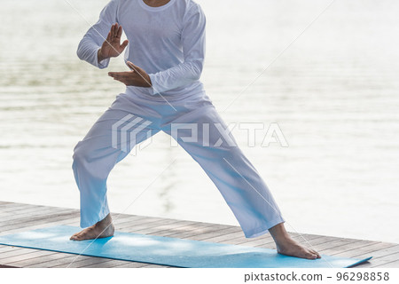 Young man practicing traditional Tai Chi Chuan, Tai Ji and Qi gong in the park for healthy, traditional chinese martial arts concept on natural background . Young man practicing traditional Tai Chi Chuan, Tai Ji and Qi gong in the park for healthy, traditional chinese martial arts concept on natural background . 96298858