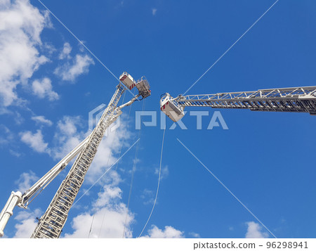 Crane construction on the cloudy bright blue sky background Crane construction on the cloudy bright blue sky background 96298941