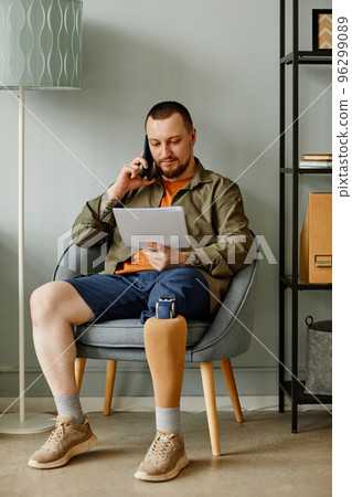 Man with prosthetic leg calling by phone 96299089