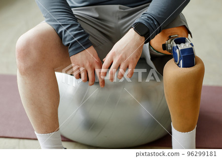 Man with prosthetic leg sitting on fitness ball Man with prosthetic leg sitting on fitness ball 96299181