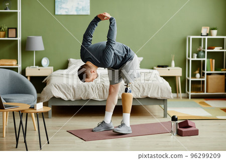 Man with prosthetic leg working out at home Man with prosthetic leg working out at home 96299209