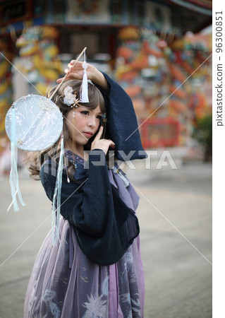 Beautiful young woman with dark blue Chinese lolita dress with Chinese garden Beautiful young woman with dark blue Chinese lolita dress with Chinese garden 96300851