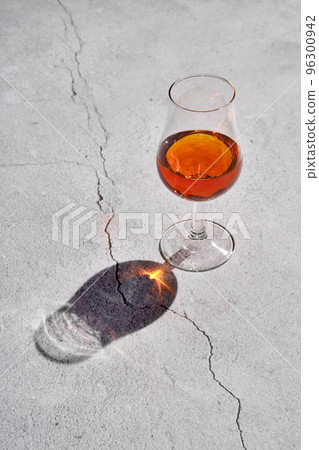 Glass of brandy on concrete surface Glass of brandy on concrete surface 96300942