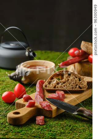 Dried sausages with bread and tomatoes on moss Dried sausages with bread and tomatoes on moss 96300949