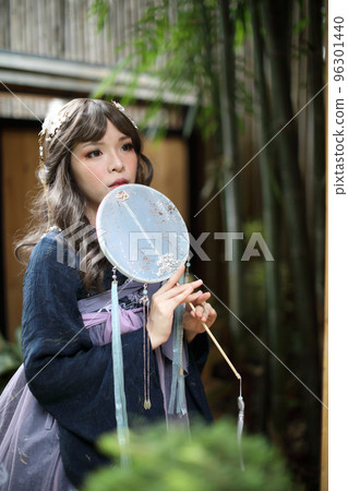 Beautiful young woman with dark blue Chinese lolita dress with Chinese garden Beautiful young woman with dark blue Chinese lolita dress with Chinese garden 96301440