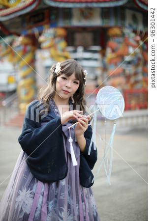 Beautiful young woman with dark blue Chinese lolita dress with Chinese garden Beautiful young woman with dark blue Chinese lolita dress with Chinese garden 96301442