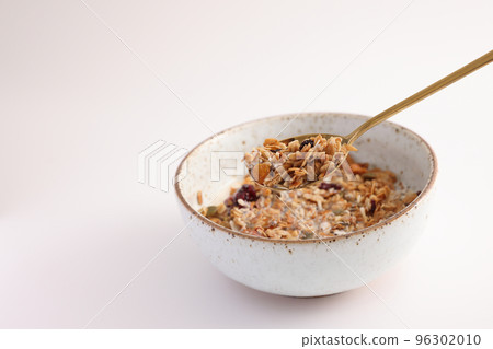 granola with milk with spoon isolated in white background 96302010