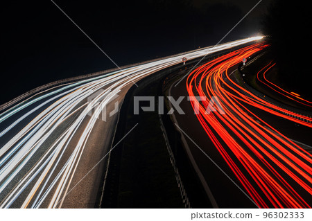 Blurred truck lights. Abstract image of night traffic lights on the road. Car light trails at night in curve asphalt road. Long exposure showing movement of cars from bridge 96302333