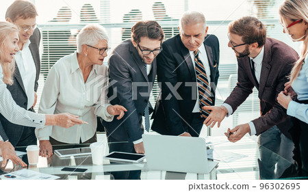 happy business team looking at the laptop screen 96302695