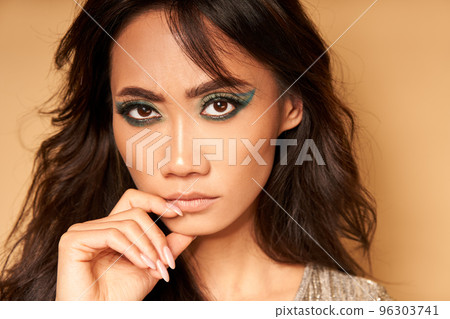 Portrait of serious confident asian woman looking to camera on beige background closeup 96303741