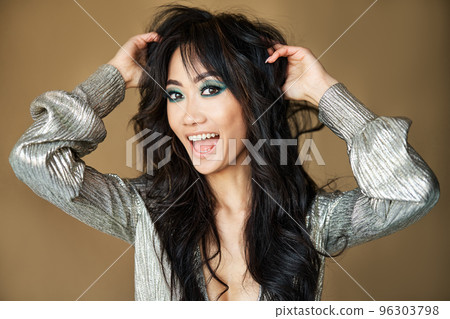 Portrait of beautiful happy girl touching her long curly hair smiling and looking to camera Portrait of beautiful happy girl touching her long curly hair smiling and looking to camera 96303798