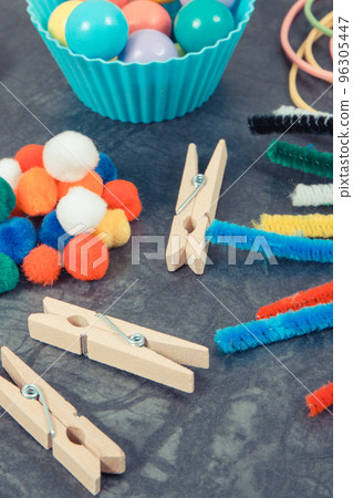 Colorful pompoms, balls and rubber erasers using for development of kids motor skills Colorful pompoms, balls and rubber erasers using for development of kids motor skills 96305447
