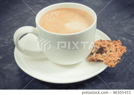 Cup of white coffee and fresh baked oatmeal cookies with honey and healthy seeds 96305455