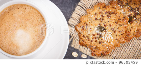 Cup of white coffee and fresh oatmeal cookies with honey and healthy seeds 96305459