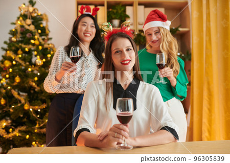 Portrait of smiling female entrepreneur and her team celebrating Christmas in office 96305839