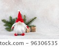 Xmas dwarf in red hat with fir branch holiday card on light winter background 96306535