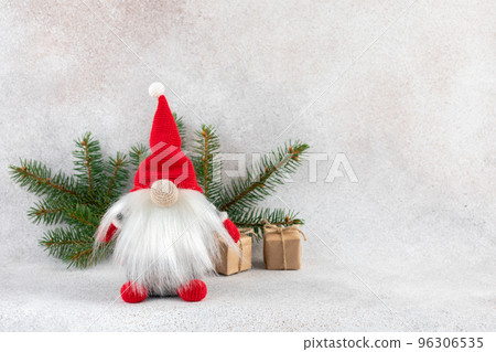Xmas dwarf in red hat with fir branch holiday card on light winter background 96306535