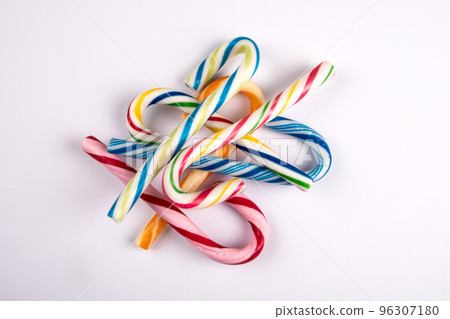 Different colored candy canes in a pile on a white background Different colored candy canes in a pile on a white background 96307180
