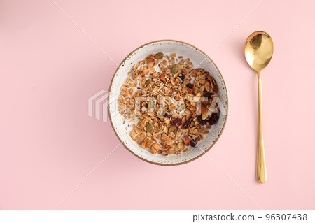 granola with milk with spoon isolated in pink background granola with milk with spoon isolated in pink background 96307438
