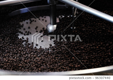 Coffee beans roasting with machine in close up Coffee beans roasting with machine in close up 96307440