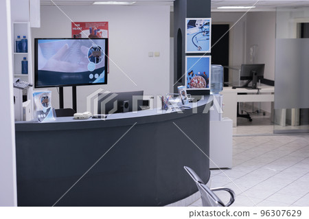 Unoccupied hospital lobby with unused computers. Administrative area with no people from medical clinic with no doctors or specialists checking patients. Sanatorium hallway with no practitioners. Unoccupied hospital lobby with unused computers. Administrative area with no people from medical clinic with no doctors or specialists checking patients. Sanatorium hallway with no practitioners. 96307629