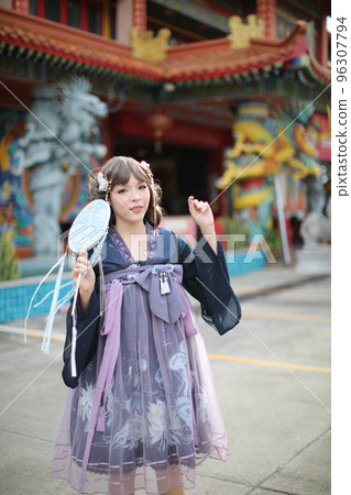 Beautiful young woman with dark blue Chinese lolita dress with Chinese garden Beautiful young woman with dark blue Chinese lolita dress with Chinese garden 96307794